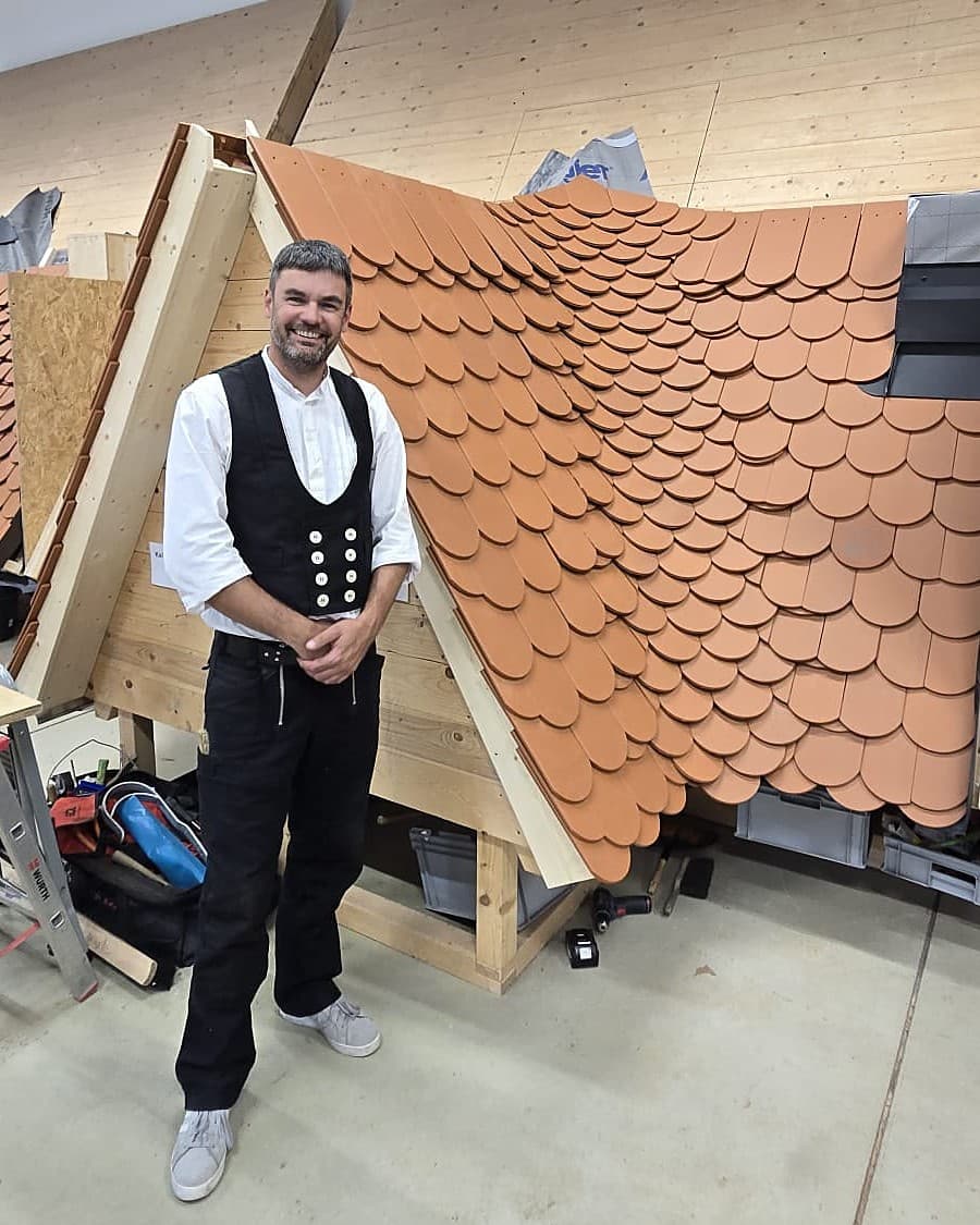 Andreas Meyer, Dachdeckermeister, vor einem mit Biberschwanzziegeln gedeckten Dachmodell